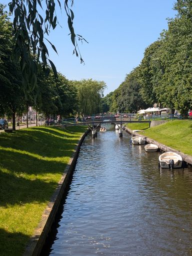 Baumgesäumter Kanal mit kleinen Booten